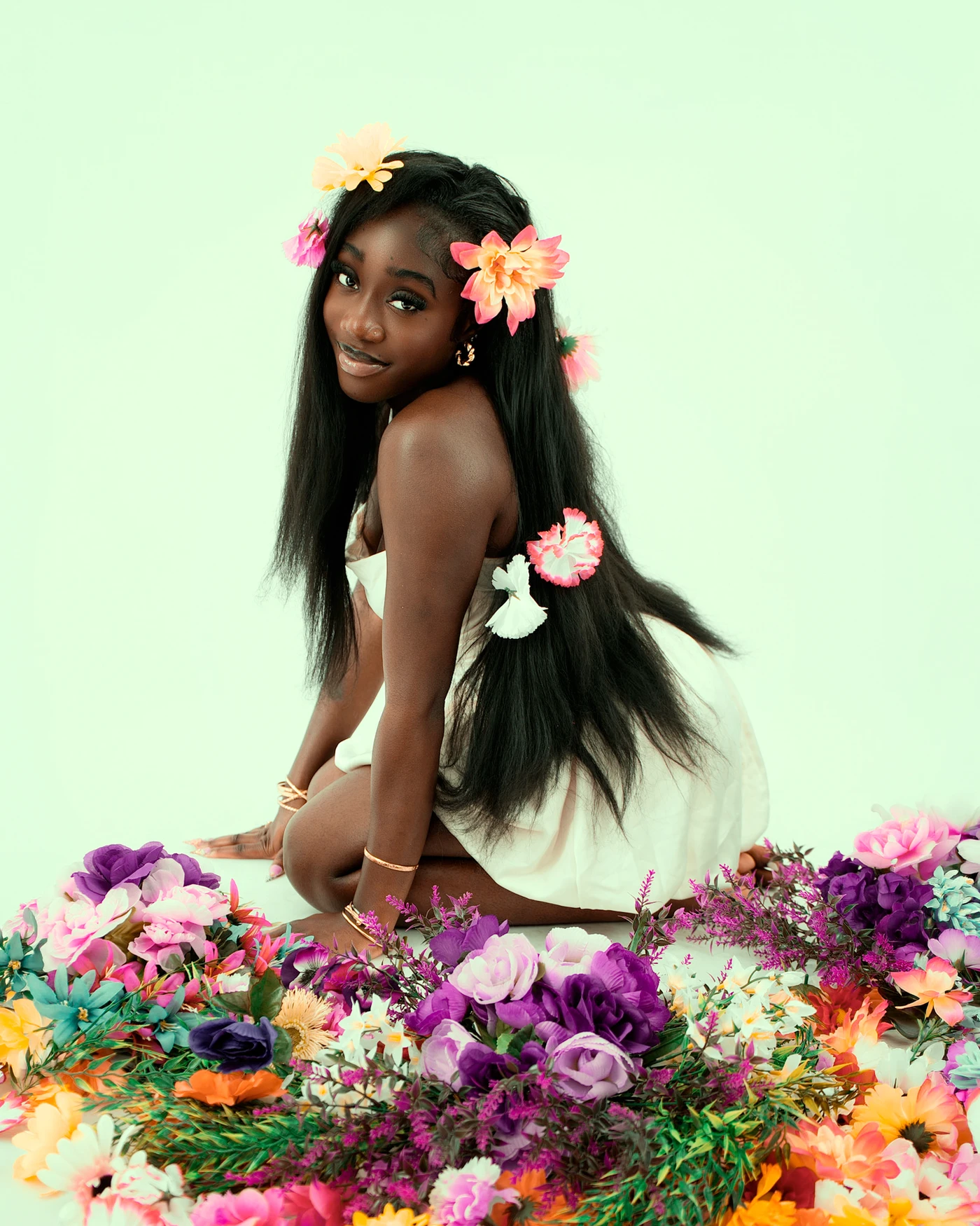 A portrait looking over one shoulder with colorful flowers in long hair