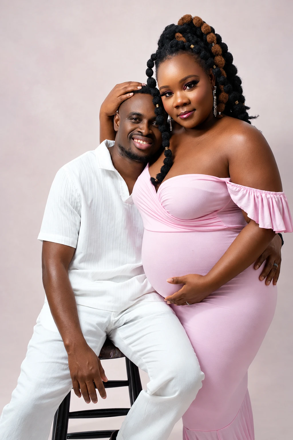 A couple smiling together in a maternity studio portrait