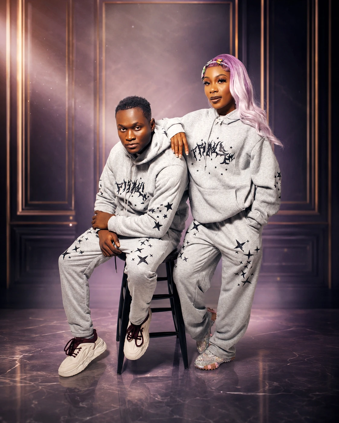 A couple in matching tracksuits posing together with a studio stool