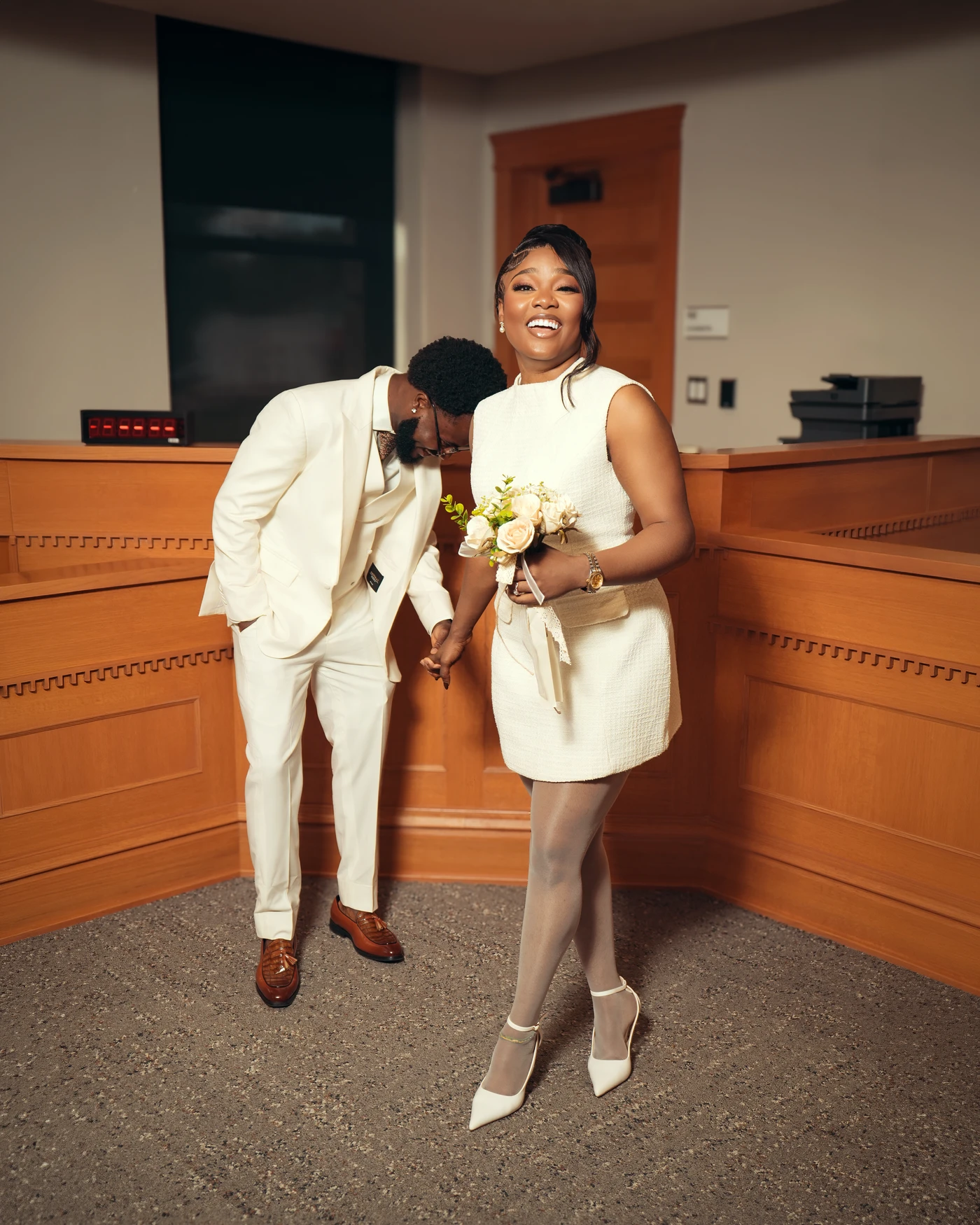 A wedding couple laughing together inside the courthouse